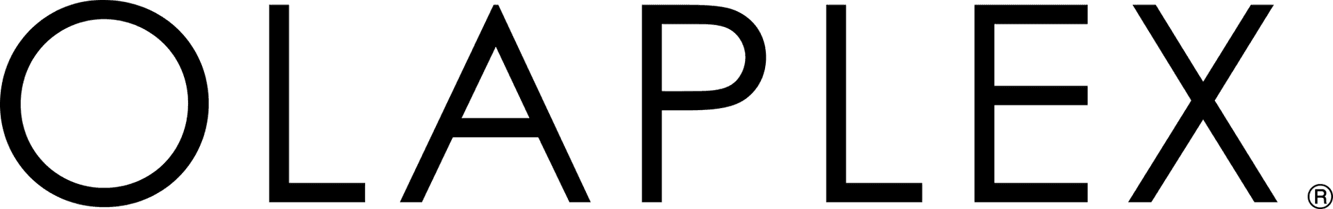 A golden retriever sitting outdoors with a scenic autumn backdrop of colorful trees.